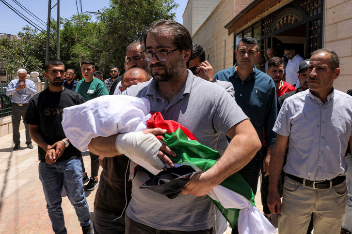 Fahd Abou Haikal, desconsolado portando el cadáver de su bebé de siete meses muerto por disparos israelíes.