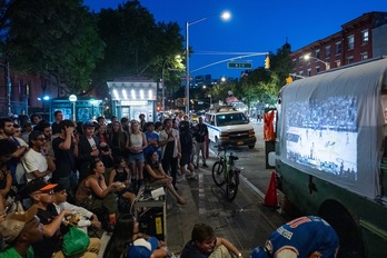 Un puñado de neoyorquinos se dispone a ver uno de los partidos de los Knicksen una pantalla improvisada con una sábana y un proyector.