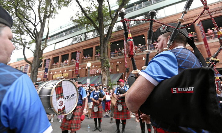 Aficionados escoceses de Tartan Army tocan la gaita por las calles de Boston vestidos con las tradicionales boinas y faldas escocesas.