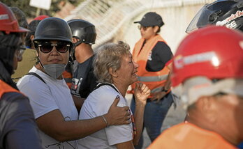 Una mujer llora tras la recuperación del cadáver de un familiar de entre los escombros de un edificio derrumbado.