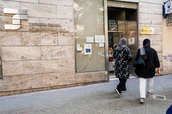Dos migrantes acuden a la oficina de la Seguridad Social en Madrid, el último día para solicitar la regularización.