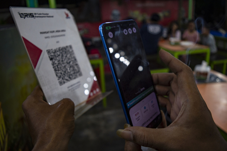Indonesiako kafetegi batean tarjetarik gabeko ordainketa bat egiten.