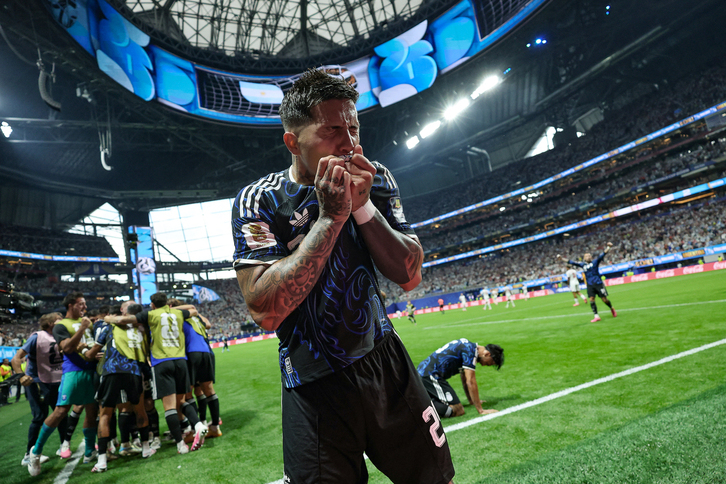 Enzo Fernández se besa el escudo mientras sus compañeros celebran el gol de la victoria.