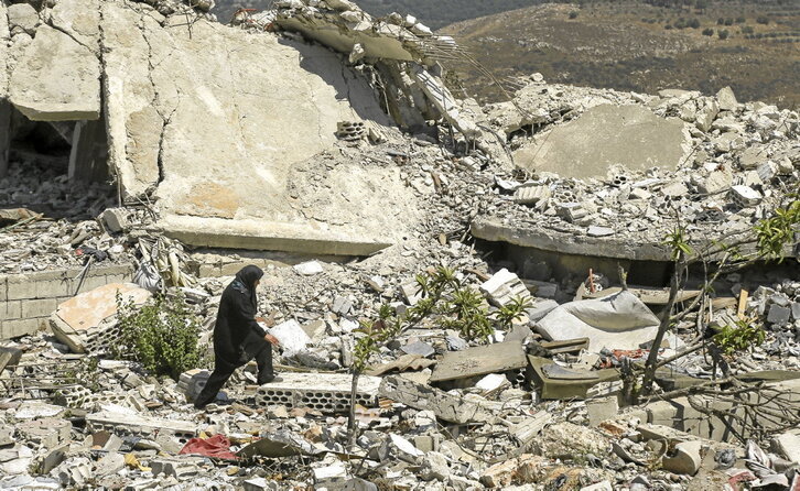 Una mujer camina sobre las ruinas de su casa en Froun, donde se ha desplegado el Ejército libanés.