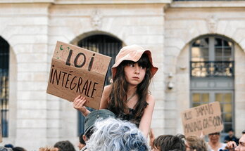 Una niña sostiene una pancarta reclamando una ley integral en una manifestación en París.