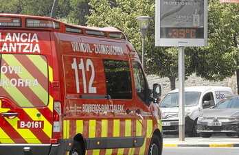 Una UVI móvil pasa delante de un termómetro urbano que marca una temperatura de 39 grados, una cifra que cada vez es más fácil de ver en las localidades de Euskal Herria.