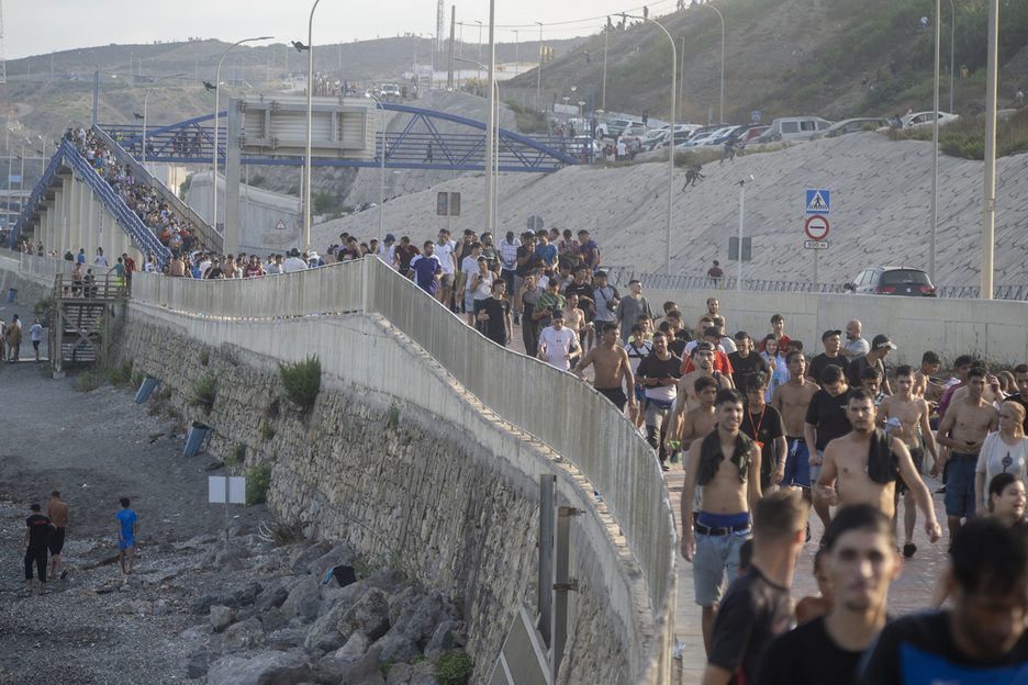 Centenares de personas caminan por Ceuta tras haber entrado en la ciudad. Centenares de personas caminan por Ceuta tras haber entrado en la ciudad.