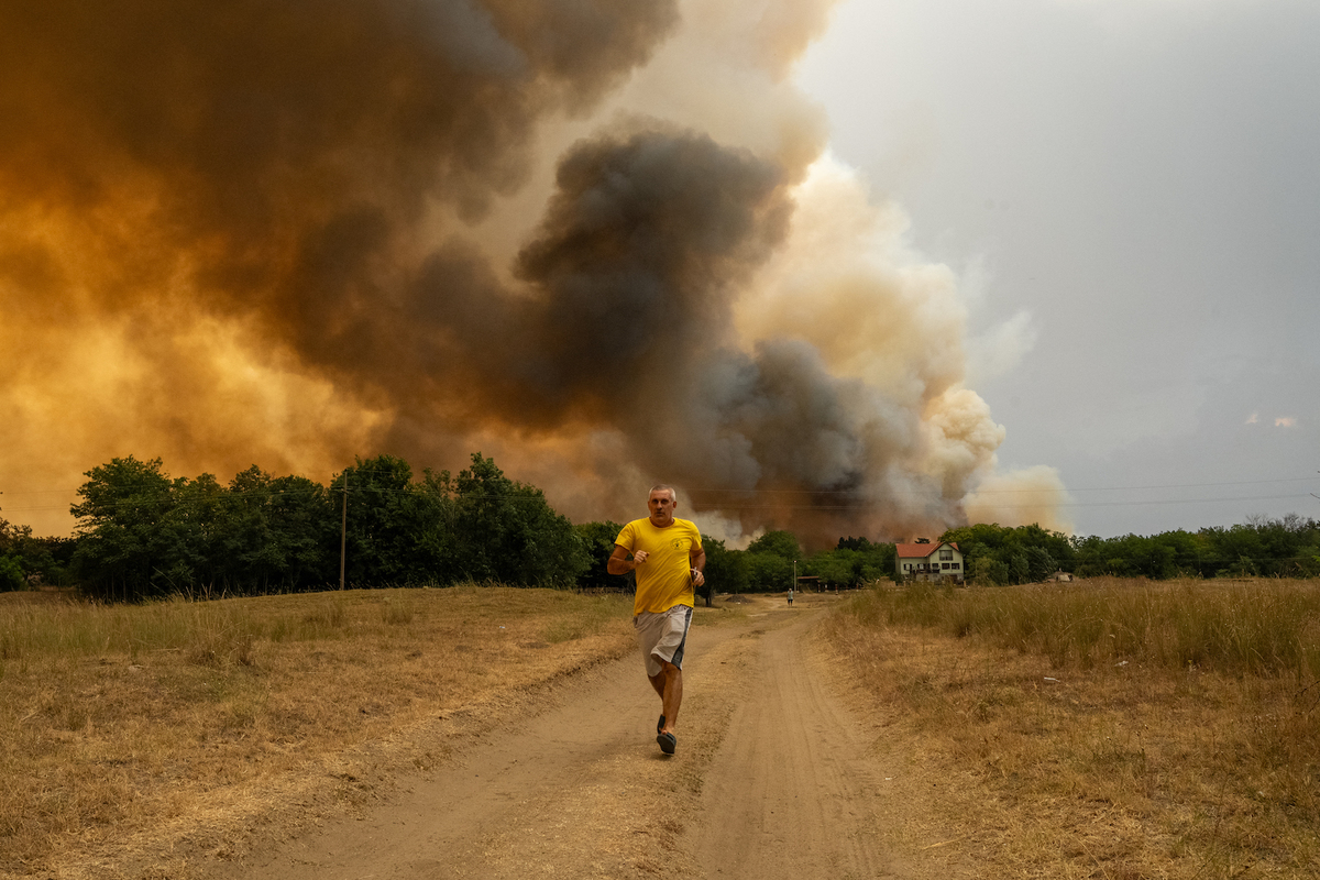 Un hombre huye de las llamas en Sumarak, Serbia. (Uros Arsic | AFP)