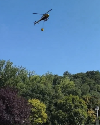 Un helicóptero recoge agua para el operativo.