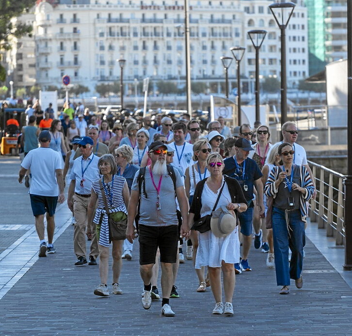 Turista multzo bat Donostiako kaira inguratzen.