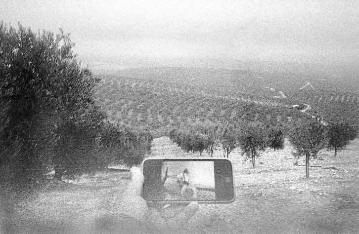 El fotoperiodista Andoni Lubaki sostiene en su mano el teléfono móvil donde se observa la fotografía del miliciano que, según Robert Capa, fue abatido en Cerro Muriano. Andoni Lubaki
