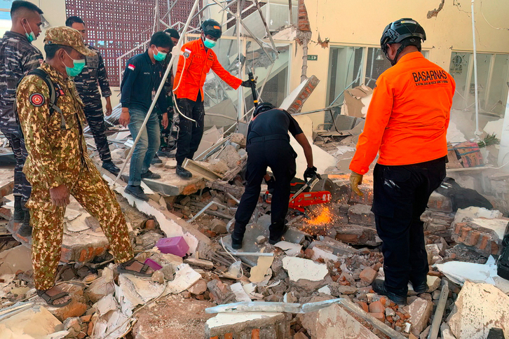Rescatistas trabajando entre los escombros de un edificio dañado tras un terremoto en Maumere, Nusa Tenggara Oriental.