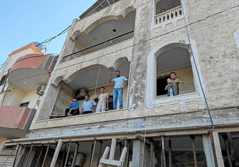 Abajo, refugiados palestinos reconstruyen un edificio bombardeado en el campo de Rashidieh. En la siguiente página, parte de la delegación internacional en la zona bombardeada de Tiro y bomberos voluntarios trabajando.