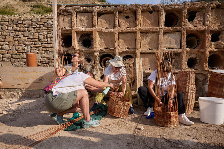Cuatro mujeres tejen las estructuras que se introducirán en el abejero para acoger los panales.