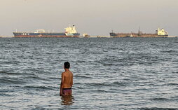 Un joven venezolano observa la partida de dos petroleros desde Lago de Maracaibo.