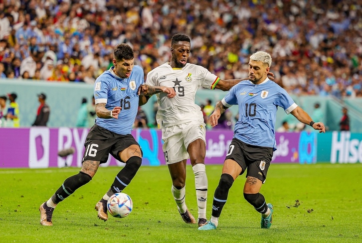 Iñaki Williams, en plena disputa por un balón contra defensores uruguayos en el Mundial de 2022.