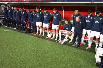 Jugadores y cuerpo técnico irlandés aganchan la cabeza durante el himno israelí.