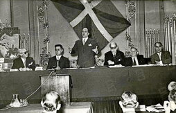 Imagen del Gobierno de Agirre presidiendo en París el I Congreso Mundial Vasco, con el lehendakari en pie, en plena intervención.