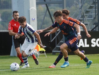 Dani Díaz, muy activo en la primera parte, se intenta ir por su banda de un rival del Granada.