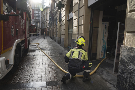 Un bombero en un comercio afectado por las inundaciones.