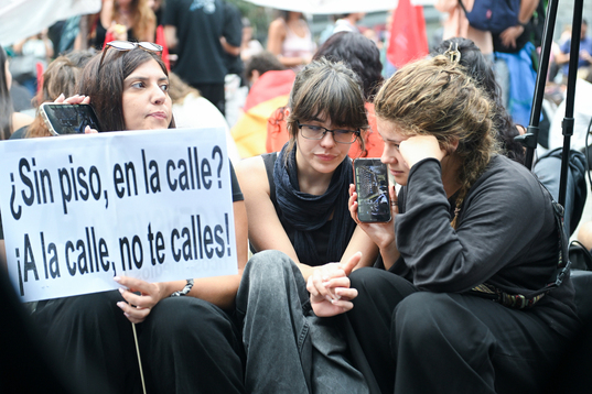 La idea de la huelga parte del Sindicato de Inquilinas. En la imagen, participantes en la acampada de la Puerta del Sol siguen por la radio la votación de los decretos.