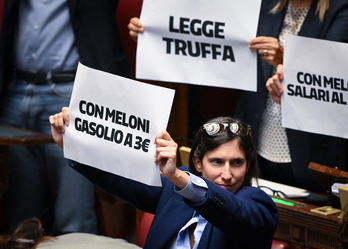 La secretaria del PD, Elly Schlein, y miembros de su partido sostienen carteles contra la nueva ley electoral y la subida de precios en el debate del jueves.
