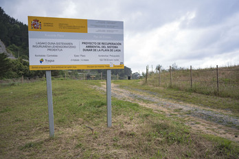 Cartel informando del proyecto de Costas en la playa de Laga.
