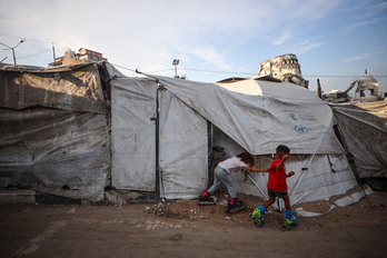 Niños palestinos desplazados juegan fuera de su tienda de campaña provisional en la ciudad de Gaza. 