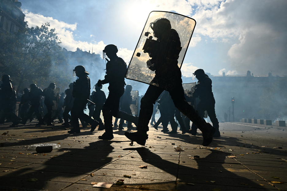 Agentes de policía persiguen a manifestantes tras el estallido de enfrentamientos. Agentes de policía persiguen a manifestantes tras el estallido de enfrentamientos.