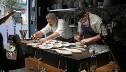 A la izquierda, Sergio Ortiz de Zarate y un cocinero de su equipo emplatan los entrantes. Encima, el plato de hígado de rape con butarga y caviar.