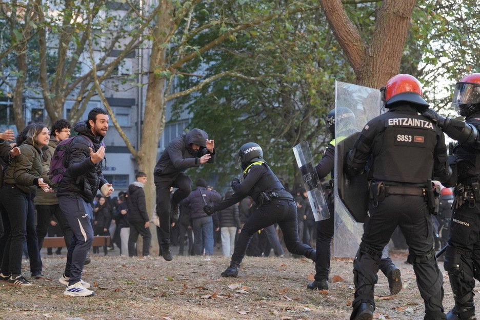 Un policía local golpea mientras los manifestantes piden calma. Un policía local golpea mientras los manifestantes piden calma.